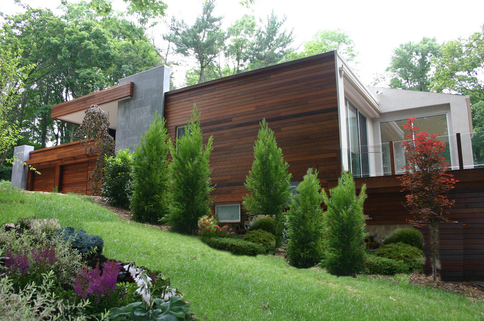 Ispirazione per la facciata di una casa marrone contemporanea a un piano di medie dimensioni con rivestimento in legno e tetto piano