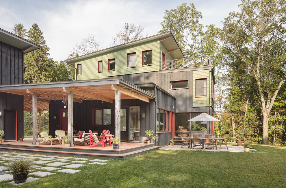 На фото: трехэтажный, деревянный, разноцветный частный загородный дом в современном стиле с односкатной крышей