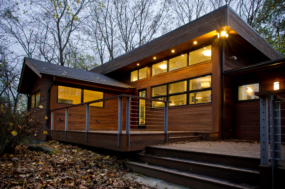 Idée de décoration pour une grande façade de maison marron design en bois à un étage avec un toit plat et un toit en shingle.