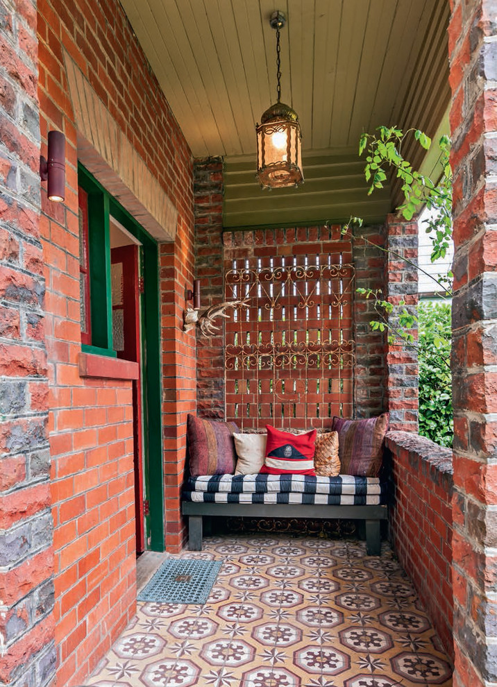 Ispirazione per la facciata di una casa verde eclettica a due piani con rivestimento in mattoni e falda a timpano