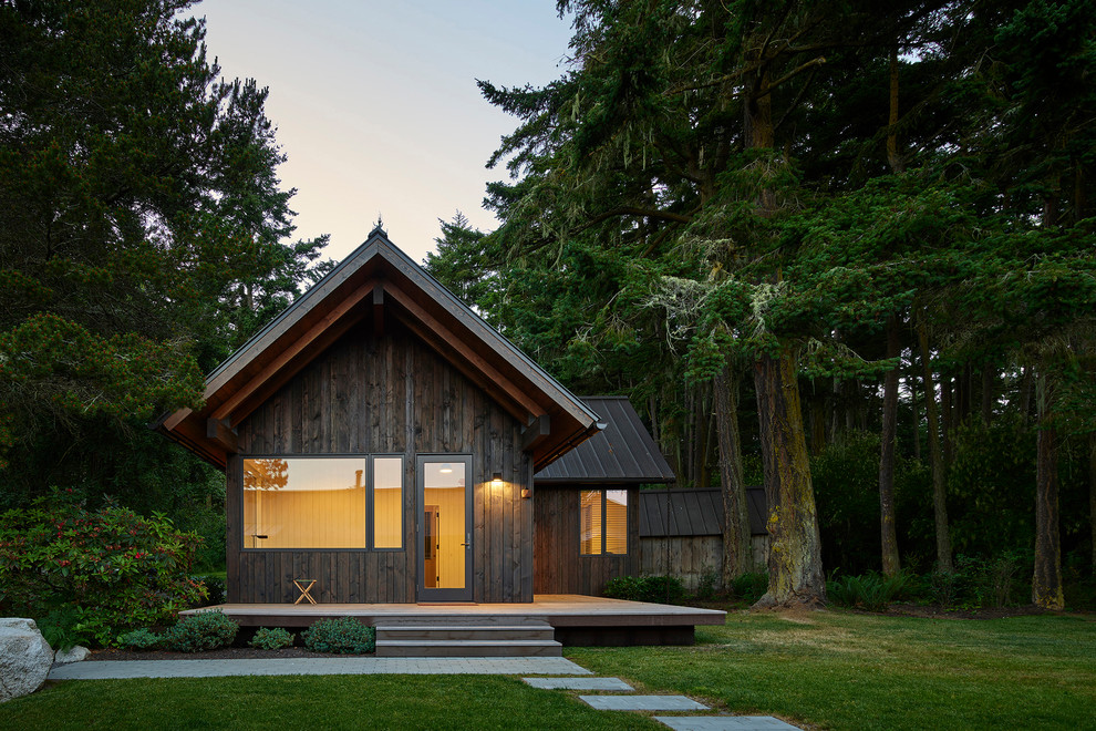 Foto della villa nera moderna a un piano con rivestimento in legno, tetto a capanna e copertura in metallo o lamiera