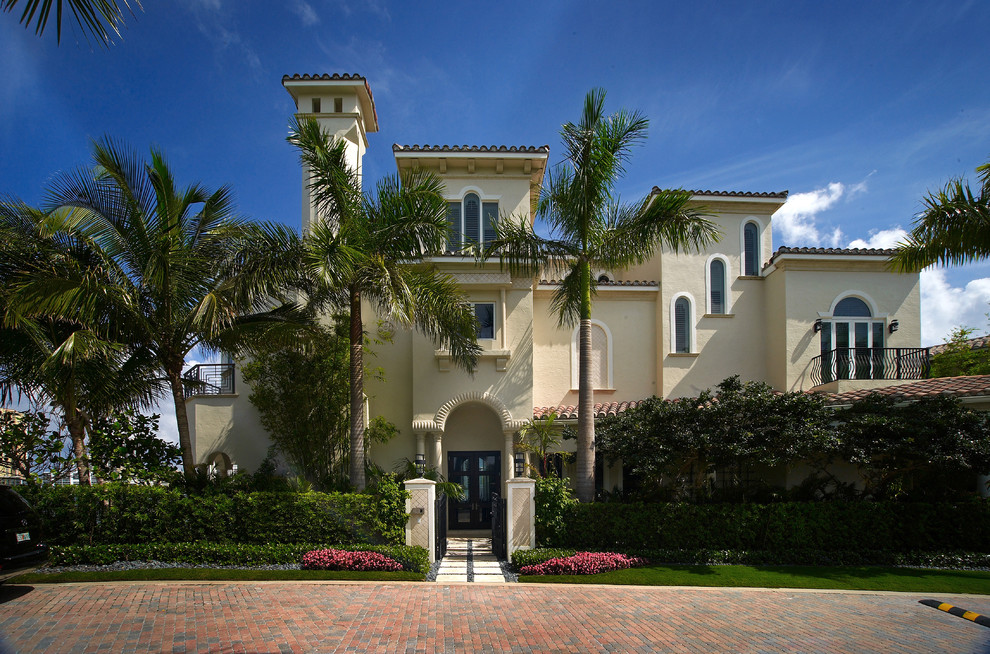 Example of a large tuscan three-story exterior home design in Miami