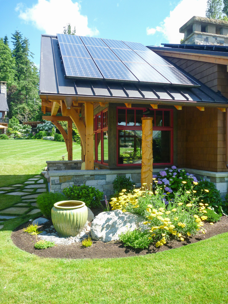 Idée de décoration pour une façade de maison marron chalet en bois de taille moyenne et de plain-pied avec un toit à deux pans et un toit en métal.