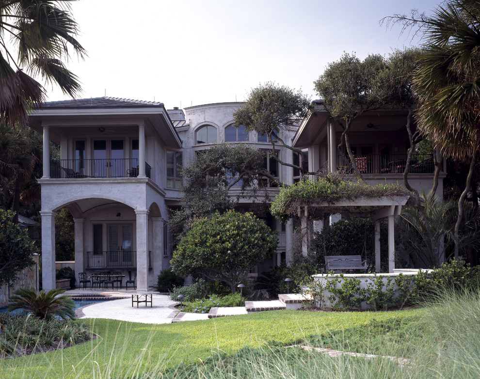 Inspiration for a large and beige mediterranean two floor render house exterior in Atlanta with a hip roof.