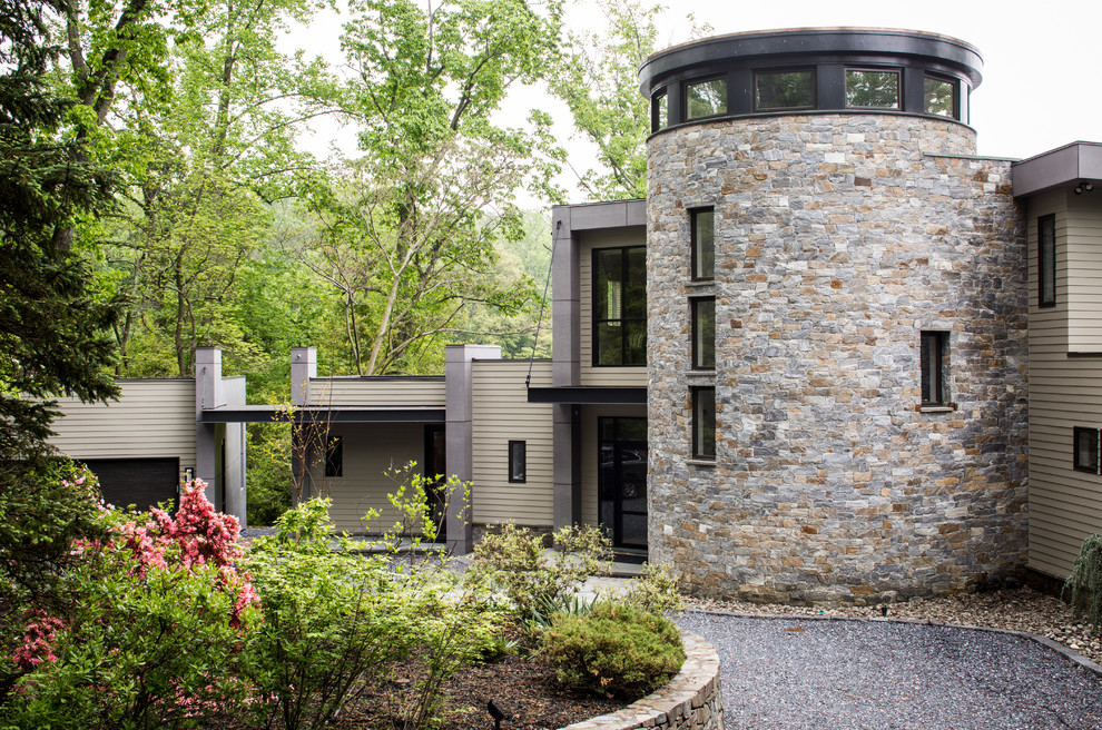 Ispirazione per la facciata di una casa beige contemporanea a tre piani con rivestimento in pietra
