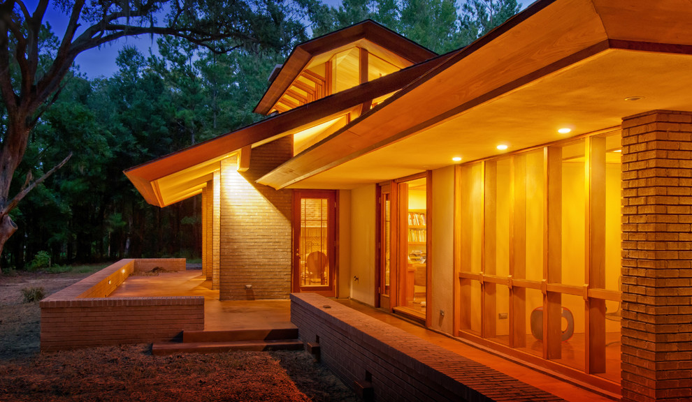 Aménagement d'une grande façade de maison beige contemporaine de plain-pied avec un revêtement mixte et un toit à deux pans.