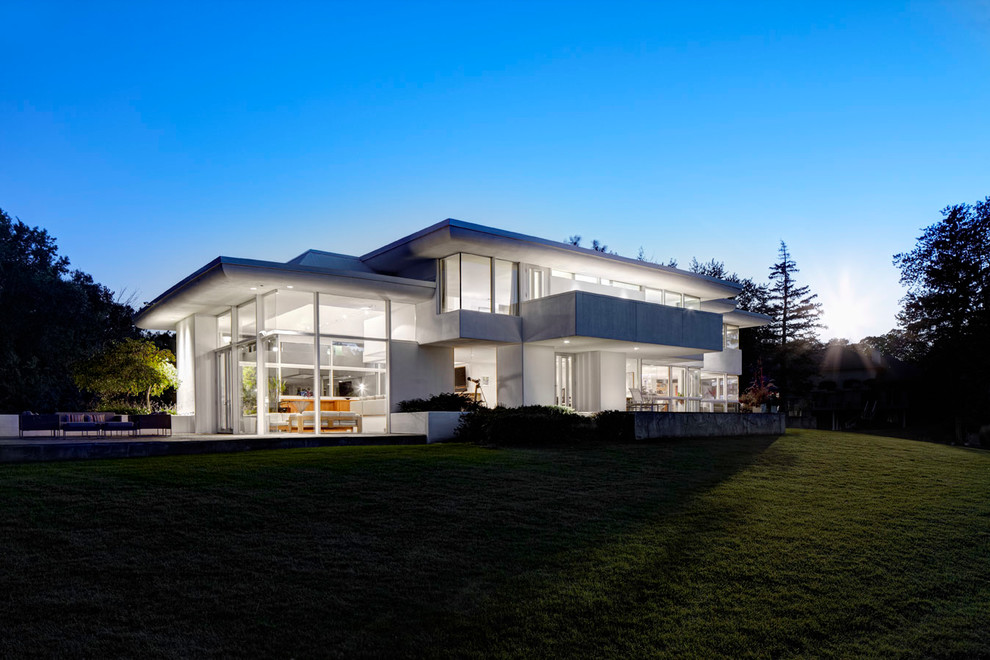 Réalisation d'une grande façade de maison grise design en stuc à un étage avec un toit plat.