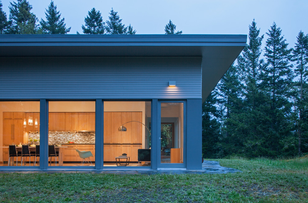 Immagine della villa marrone contemporanea a un piano di medie dimensioni con rivestimento in legno, tetto piano e copertura verde