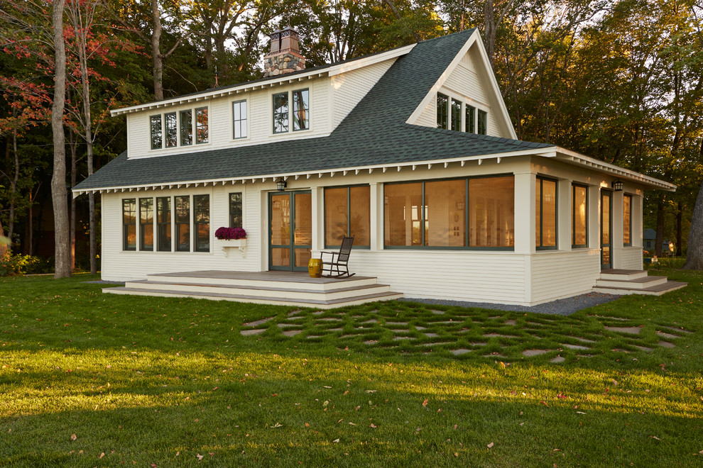 На фото: двухэтажный, деревянный, белый дом в классическом стиле с двускатной крышей для охотников с