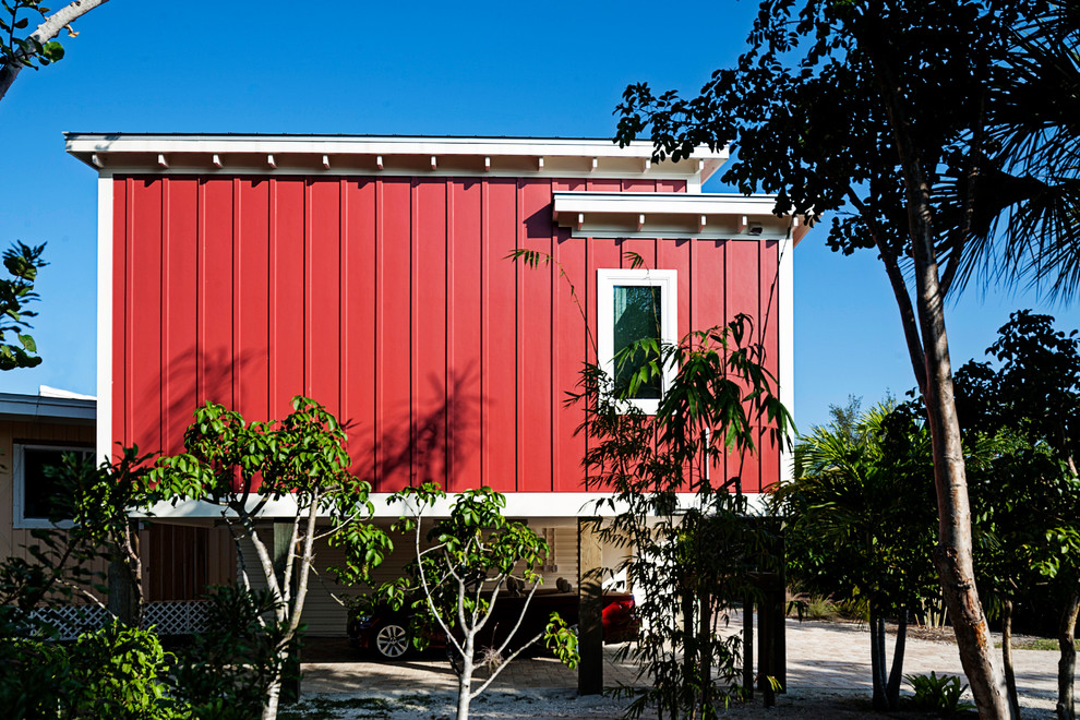 Example of a small minimalist red one-story wood flat roof design in Miami