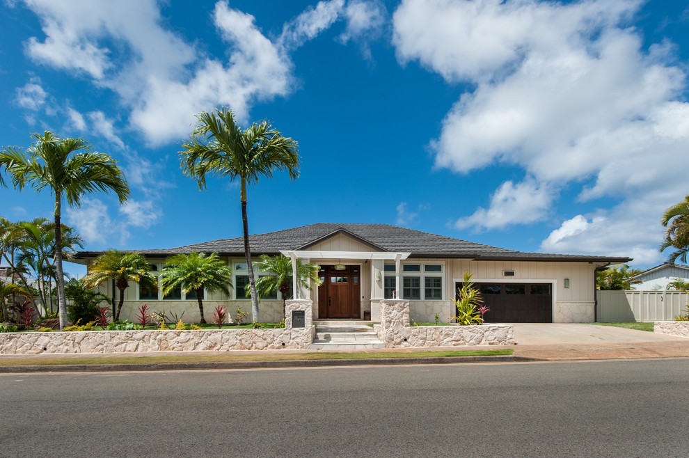 Large and beige traditional bungalow house exterior in Hawaii.