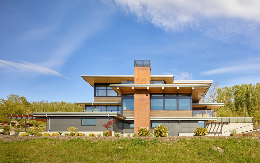 Exempel på ett modernt hus, med tre eller fler plan, blandad fasad och platt tak