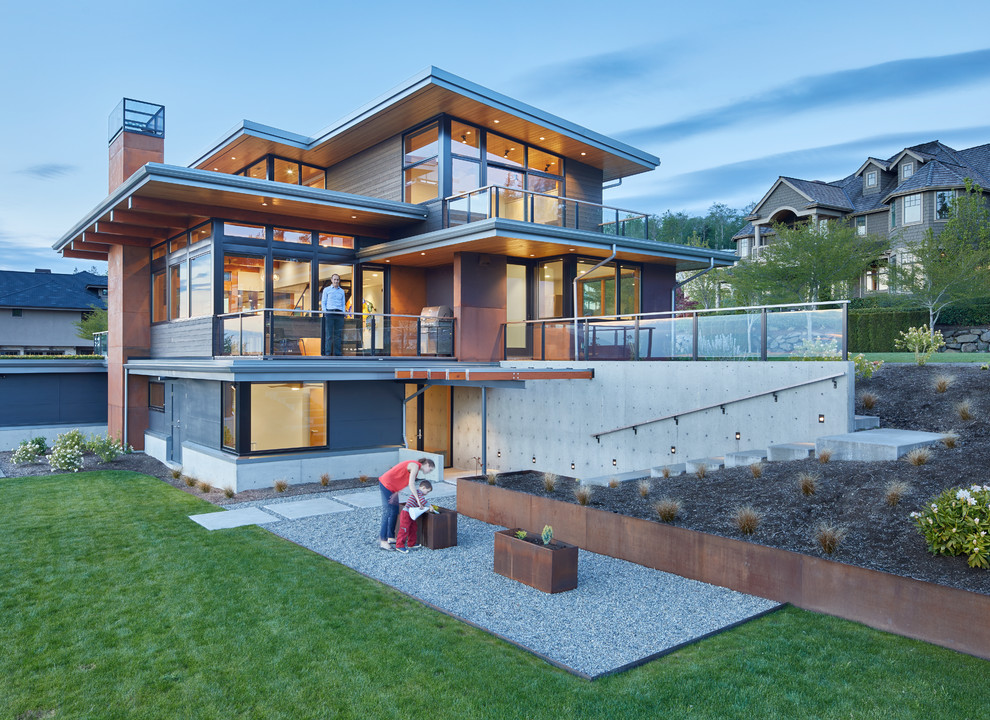 Cette image montre une façade de maison métallique et marron design à deux étages et plus avec un toit en appentis et un toit en métal.
