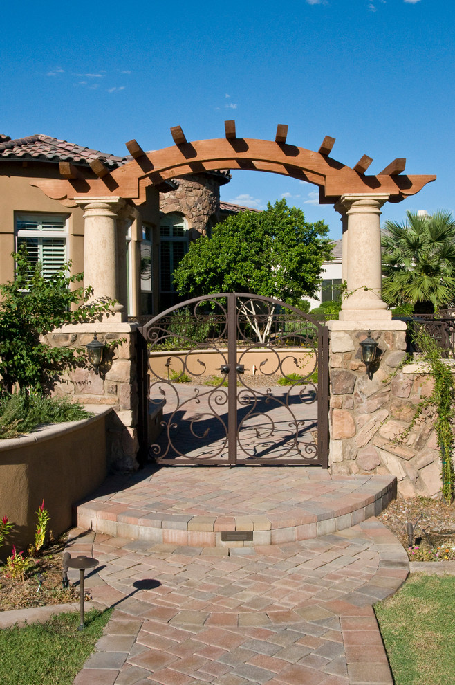 Large tuscan gray one-story stone exterior home photo in Phoenix
