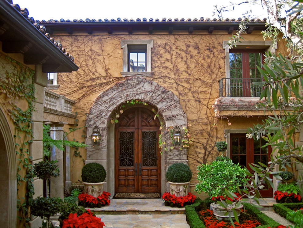 Mittelgroßes, Zweistöckiges Mediterranes Haus mit Backsteinfassade, beiger Fassadenfarbe und Flachdach in Orange County