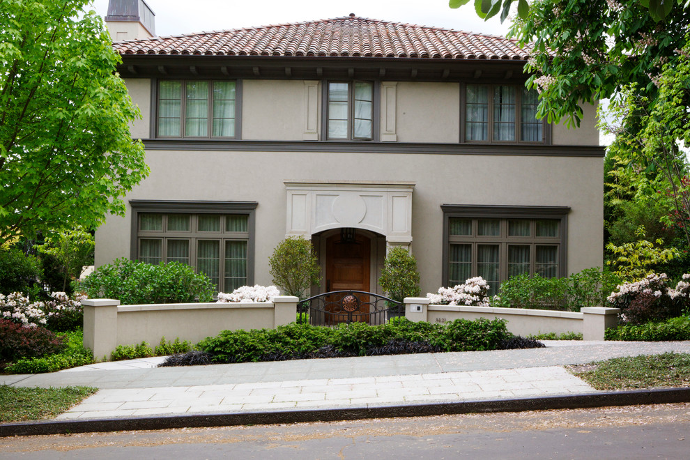 Inspiration for a beige mediterranean two floor house exterior in Seattle with a tiled roof.