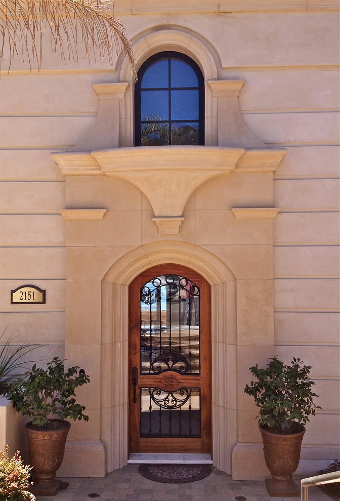 Diseño de fachada beige mediterránea grande de tres plantas con revestimiento de estuco y tejado plano