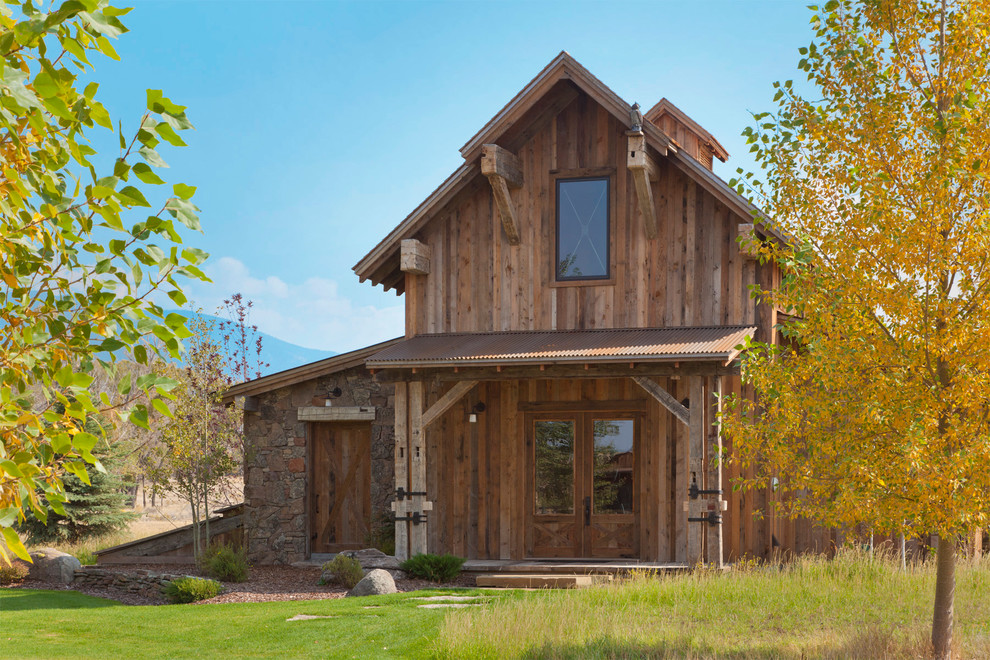 На фото: деревянный, двухэтажный, коричневый дом в стиле рустика с