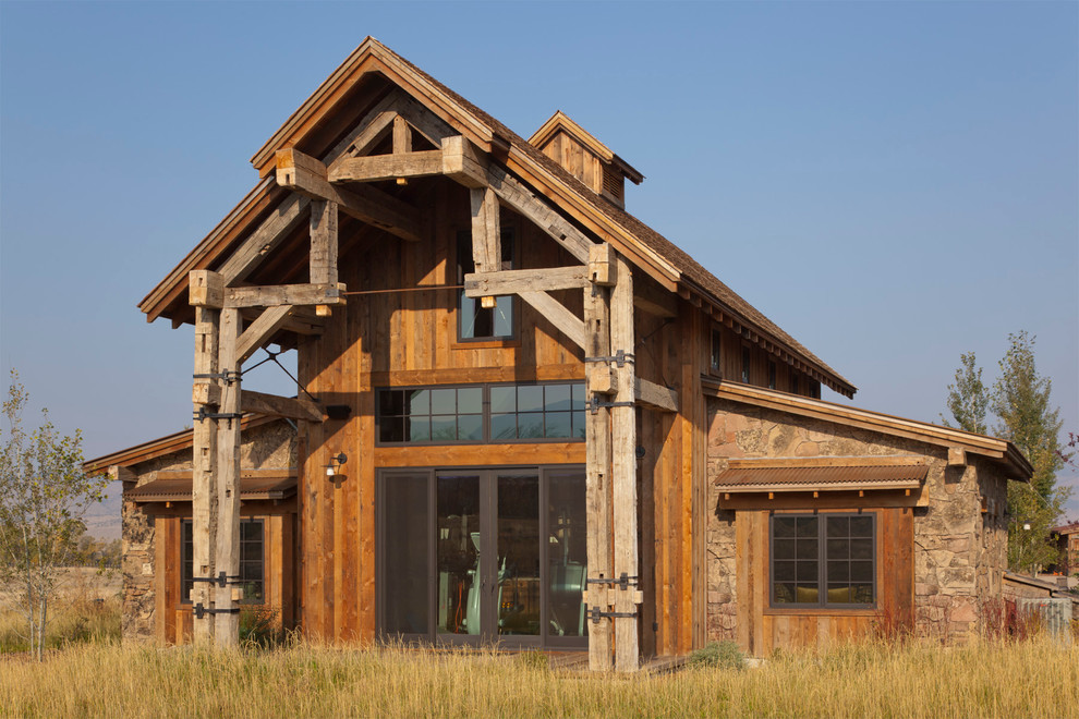 На фото: деревянный, двухэтажный, коричневый дом среднего размера в стиле рустика с односкатной крышей