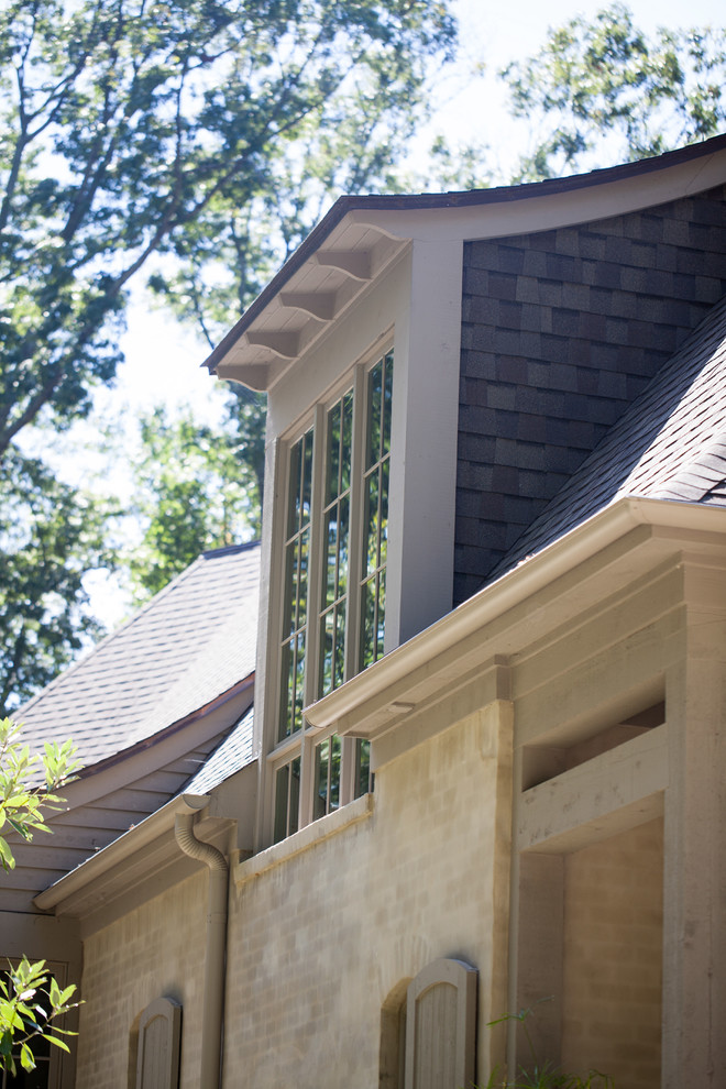 Modelo de fachada de casa beige clásica grande de dos plantas con revestimiento de ladrillo, tejado a cuatro aguas y tejado de teja de madera