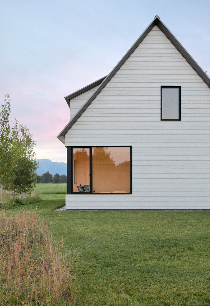 Diseño de fachada de casa blanca de estilo de casa de campo de tamaño medio de dos plantas con revestimiento de madera, tejado a dos aguas y tejado de metal