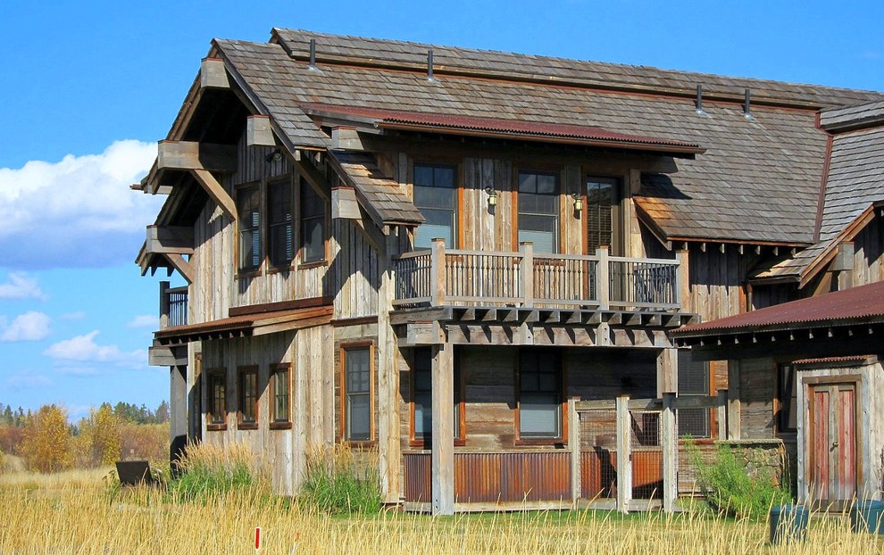 Exemple d'une façade de maison grise montagne en bois à un étage et de taille moyenne avec un toit à deux pans.