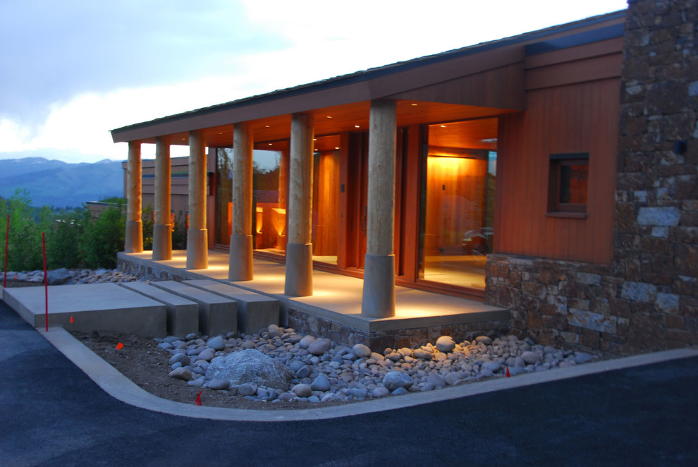 Стильный дизайн: большой, двухэтажный, коричневый дом в стиле рустика с комбинированной облицовкой и двускатной крышей - последний тренд