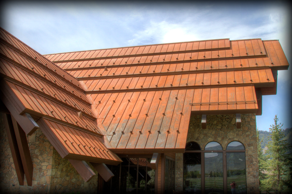 Inspiration for a mid-sized rustic brown two-story stone exterior home remodel in Other with a metal roof