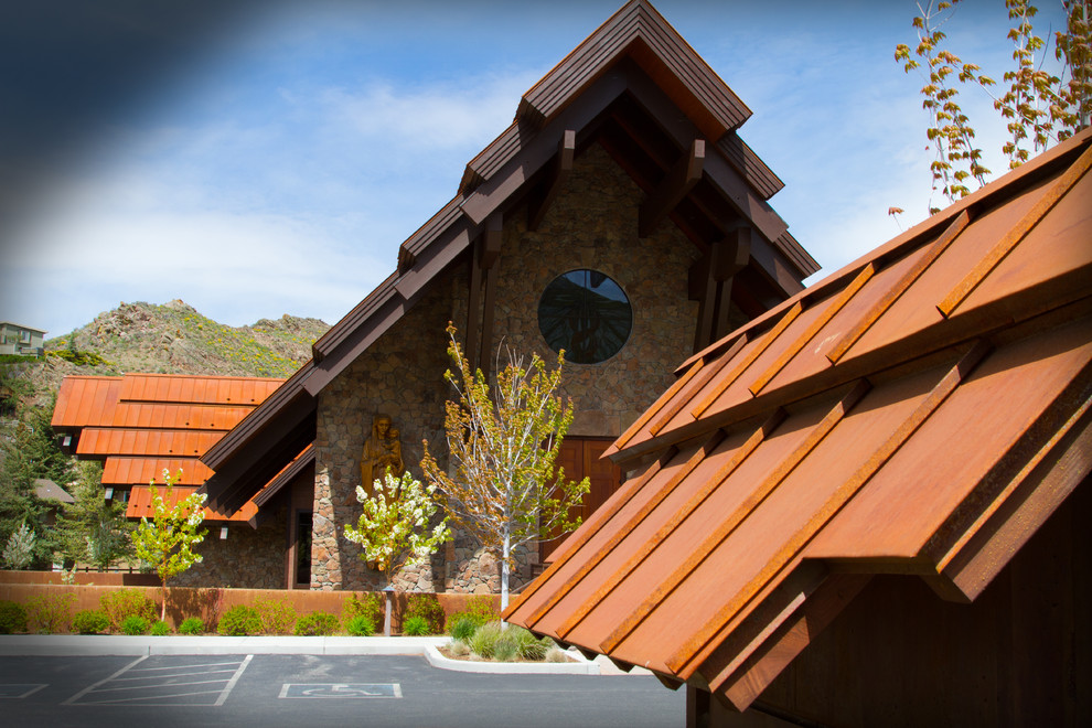 Mid-sized mountain style brown two-story stone exterior home photo in Other with a metal roof