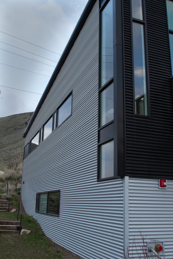 Großes, Zweistöckiges Uriges Haus mit Metallfassade, grauer Fassadenfarbe, Flachdach und Blechdach in Sonstige