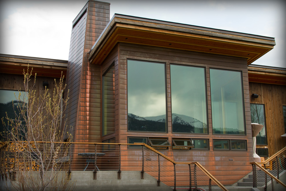 Example of a mid-sized mountain style brown one-story metal house exterior design in Other with a hip roof