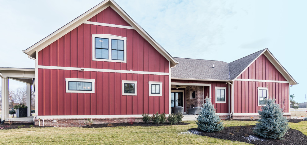 Cette image montre une grande façade de maison rouge craftsman en bois à un étage.
