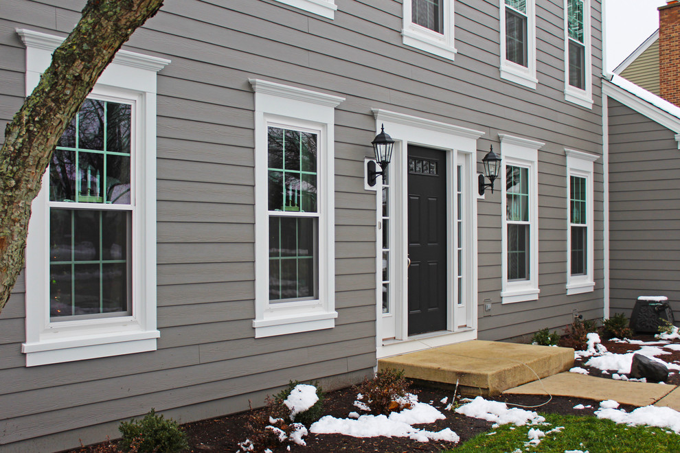 This is an example of a medium sized and gey traditional two floor detached house in Chicago with concrete fibreboard cladding.