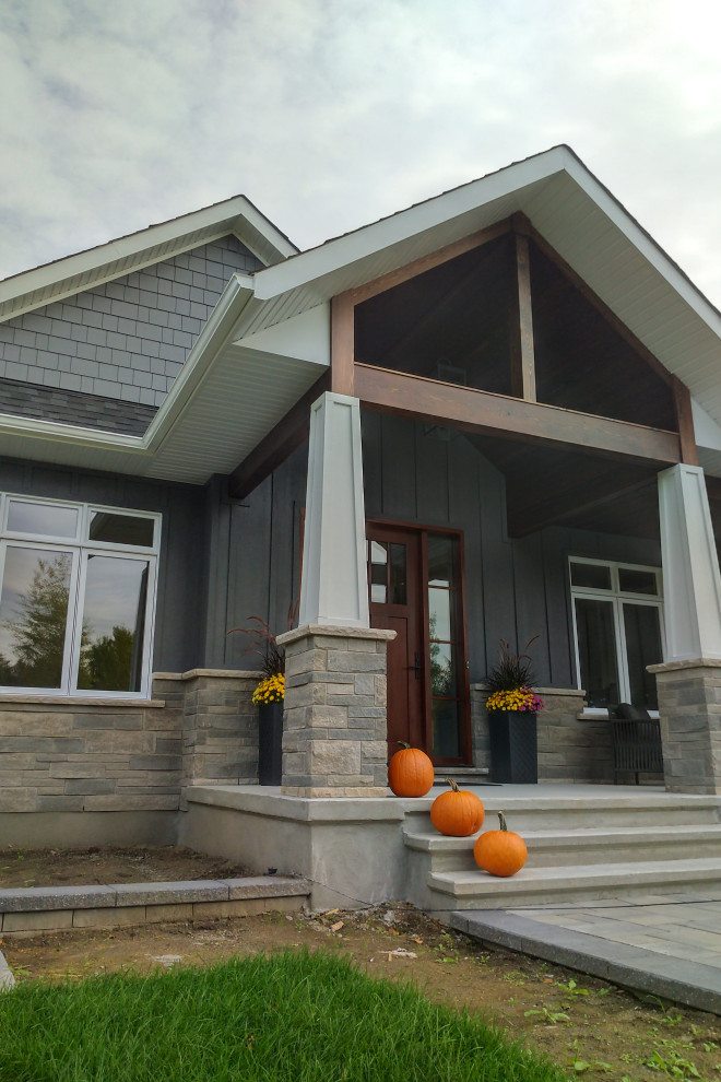 Ejemplo de fachada de casa gris clásica de una planta con revestimiento de aglomerado de cemento y tejado de teja de madera