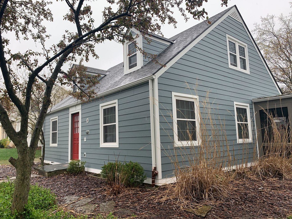 Пример оригинального дизайна: синий частный загородный дом в современном стиле с облицовкой из ЦСП, двускатной крышей и крышей из гибкой черепицы