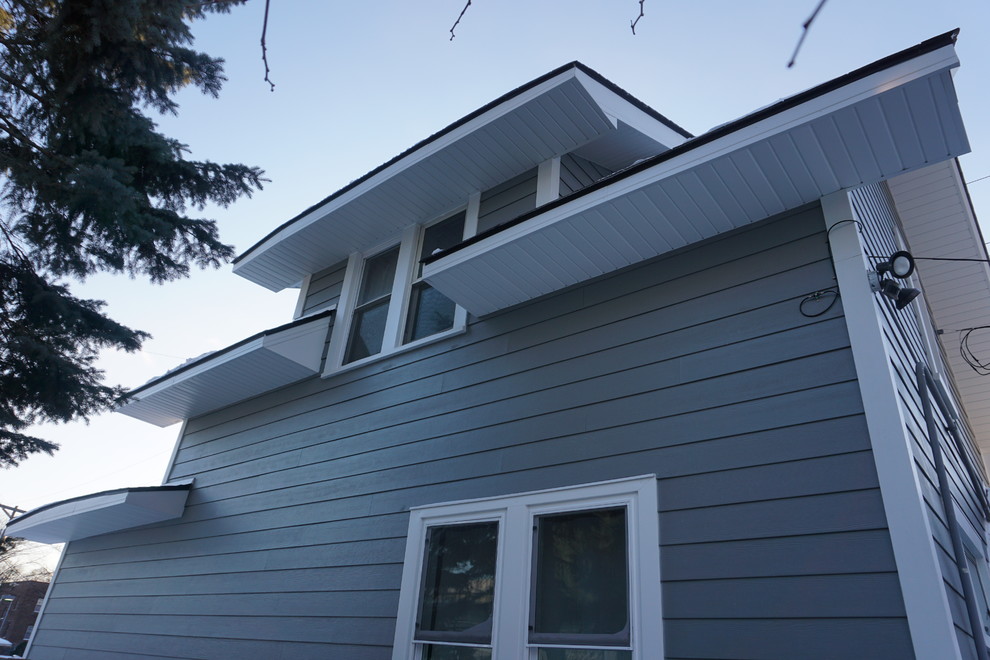 Photo of a large and gey traditional two floor house exterior in Minneapolis with concrete fibreboard cladding and a pitched roof.