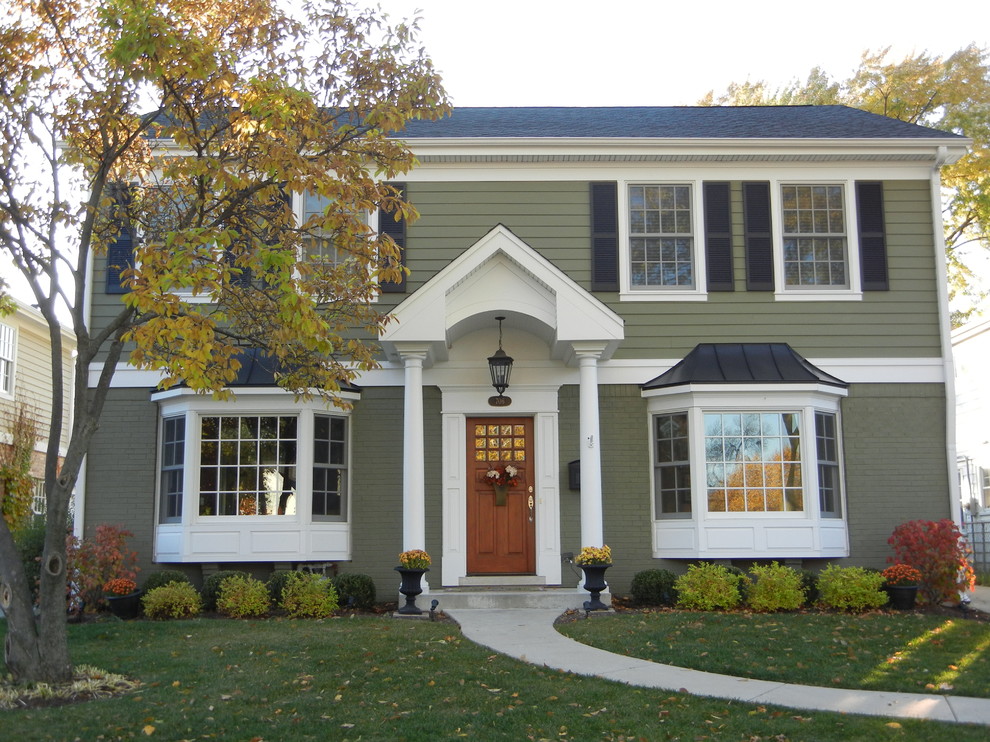 This is an example of a medium sized and green classic two floor house exterior in Chicago with mixed cladding and a pitched roof.