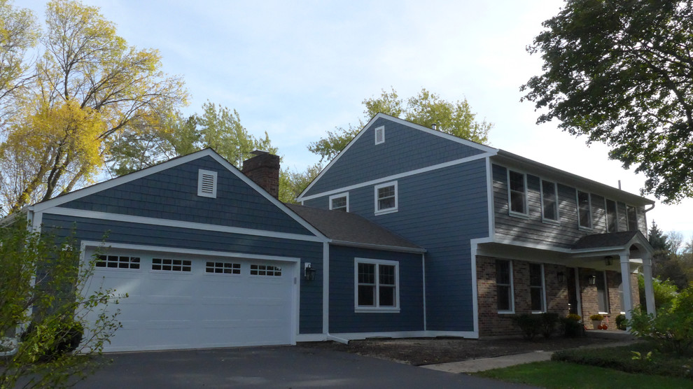 Ejemplo de fachada de casa azul tradicional de tamaño medio a niveles con revestimientos combinados, tejado a dos aguas y tejado de teja de madera