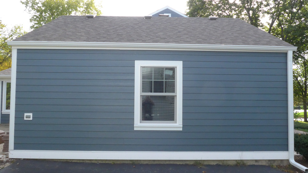 Imagen de fachada de casa azul clásica de tamaño medio a niveles con revestimientos combinados, tejado a dos aguas y tejado de teja de madera