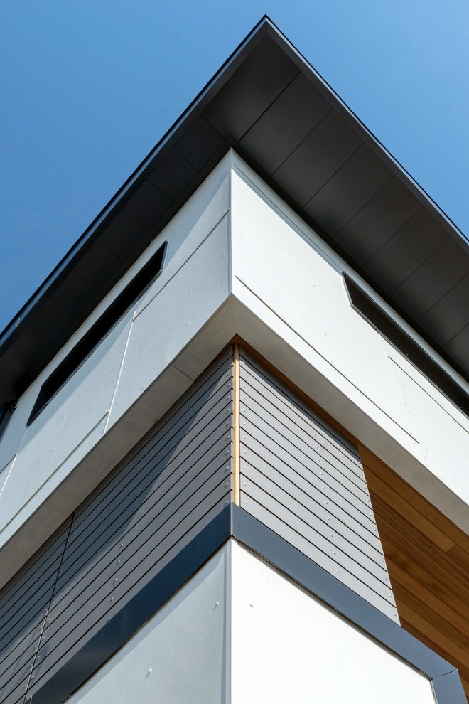Immagine della facciata di una casa bianca moderna con rivestimenti misti