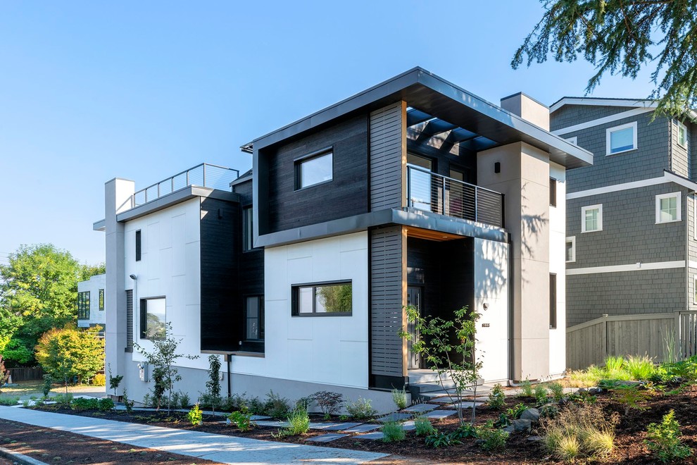 Imagen de fachada de casa blanca contemporánea de dos plantas con revestimientos combinados y tejado plano