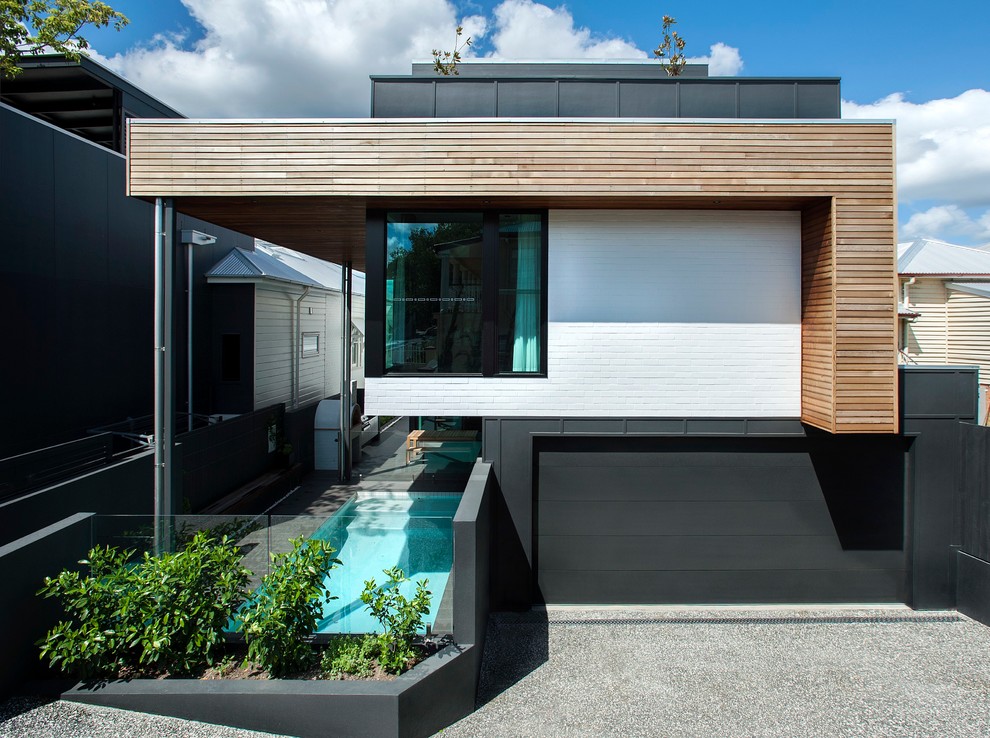 Идея дизайна: двухэтажный, черный частный загородный дом в современном стиле с комбинированной облицовкой и плоской крышей