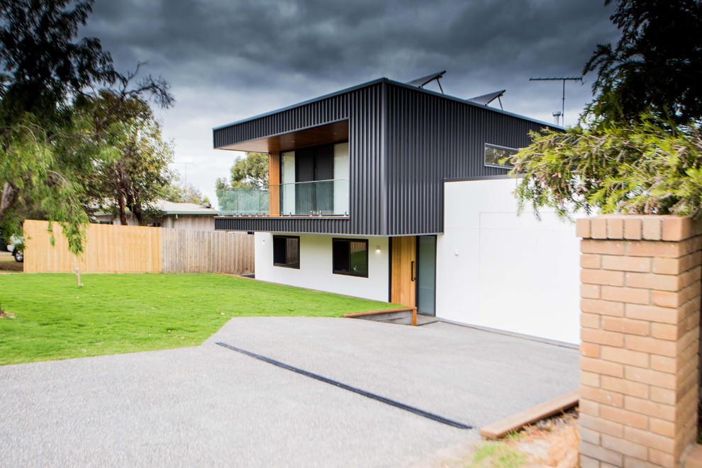 Large and black contemporary two floor detached house in Geelong with metal cladding, a flat roof and a metal roof.