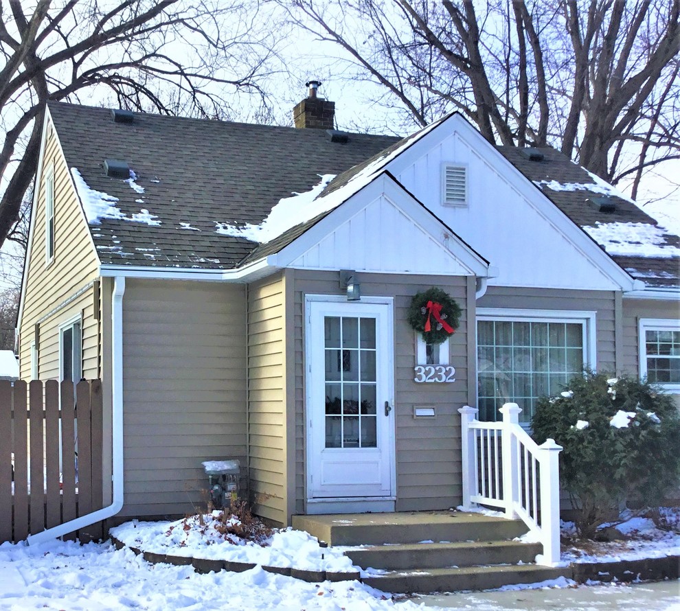 Cette photo montre une façade de maison beige rétro de taille moyenne et de plain-pied avec un toit en shingle.