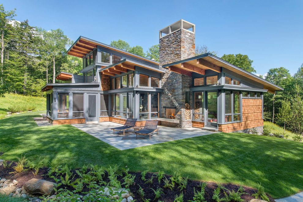 Example of a mountain style gray wood house exterior design in Burlington with a shed roof
