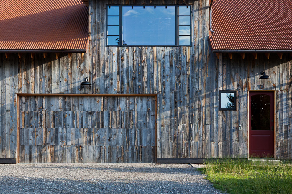 Ejemplo de fachada marrón rural de tamaño medio de dos plantas con revestimiento de madera y tejado a dos aguas