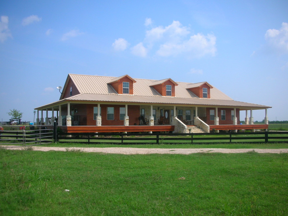 Foto della facciata di una casa grande bianca country a un piano con rivestimento in pietra