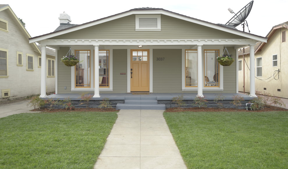 Réalisation d'une façade de maison verte craftsman en bois de taille moyenne et de plain-pied.