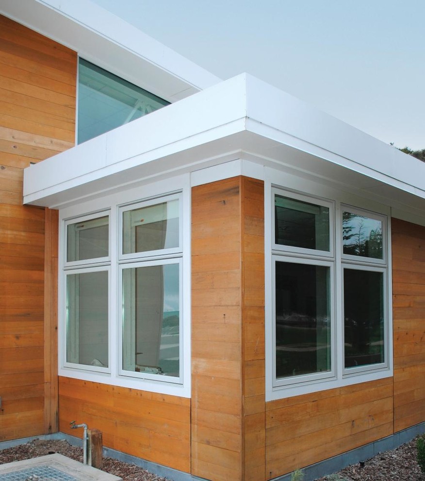 Immagine della facciata di una casa beige moderna a due piani di medie dimensioni con rivestimento in legno e tetto piano