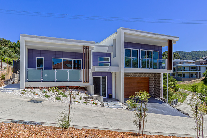 Cette photo montre une grande façade de maison violet tendance à niveaux décalés avec un revêtement mixte et un toit plat.